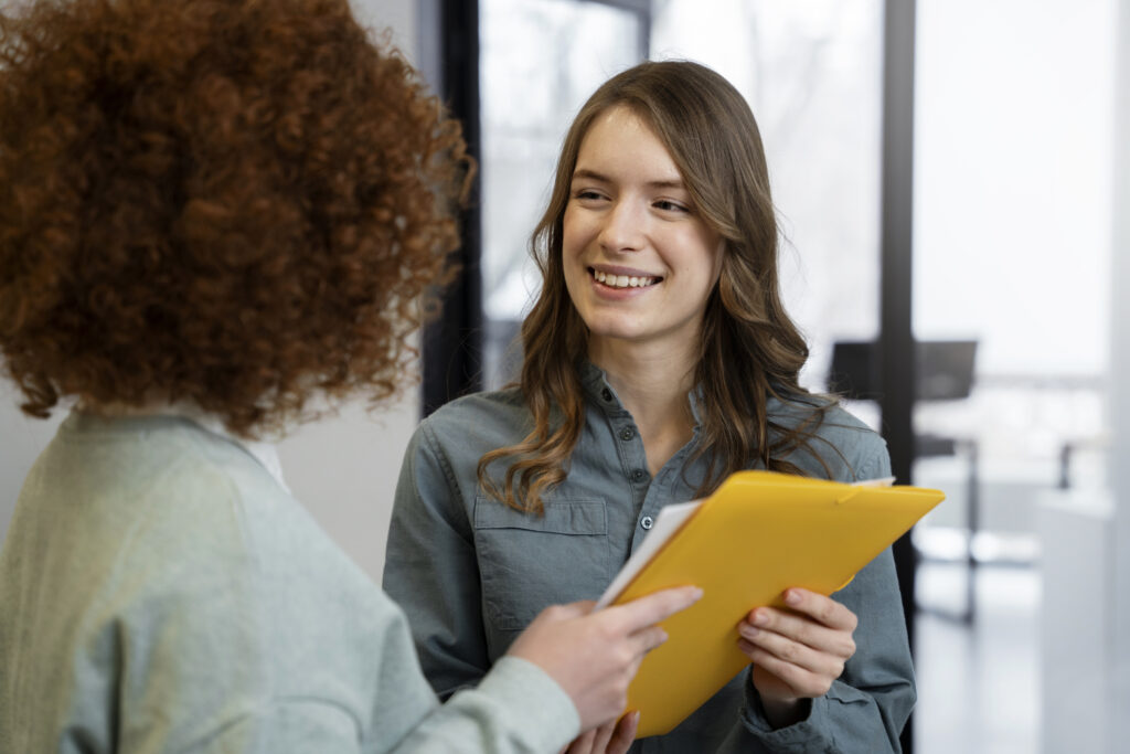 Jovem em uma processo de entrevista de emprego, entregando seu curriculo.